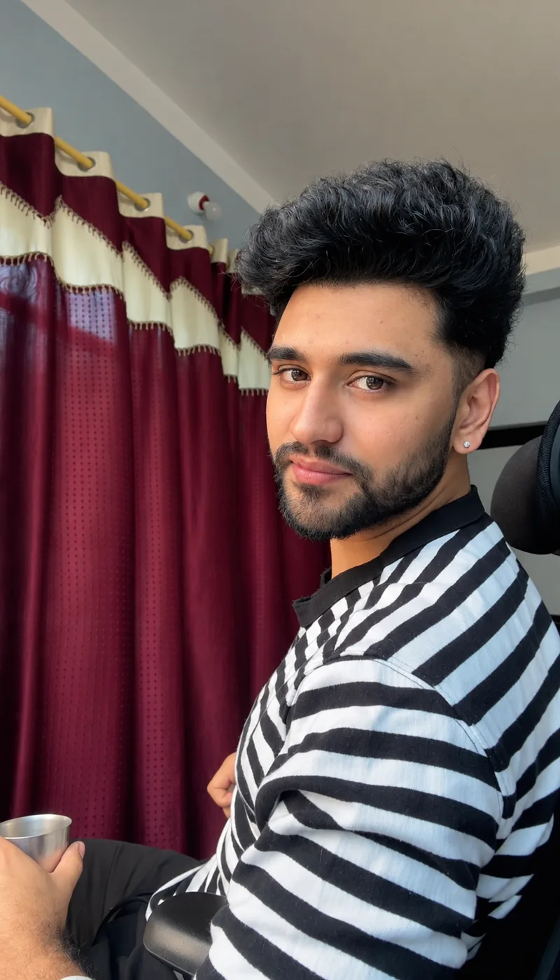 Vishal Bhattarai in a striped shirt in front of burgundy curtains